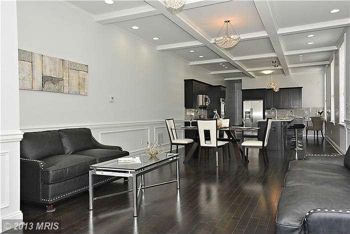 2040 E. Pratt Street after renovation. White painted walls, black kitchen cabinets, white painted ceiling beams, and staged with black and white furniture.