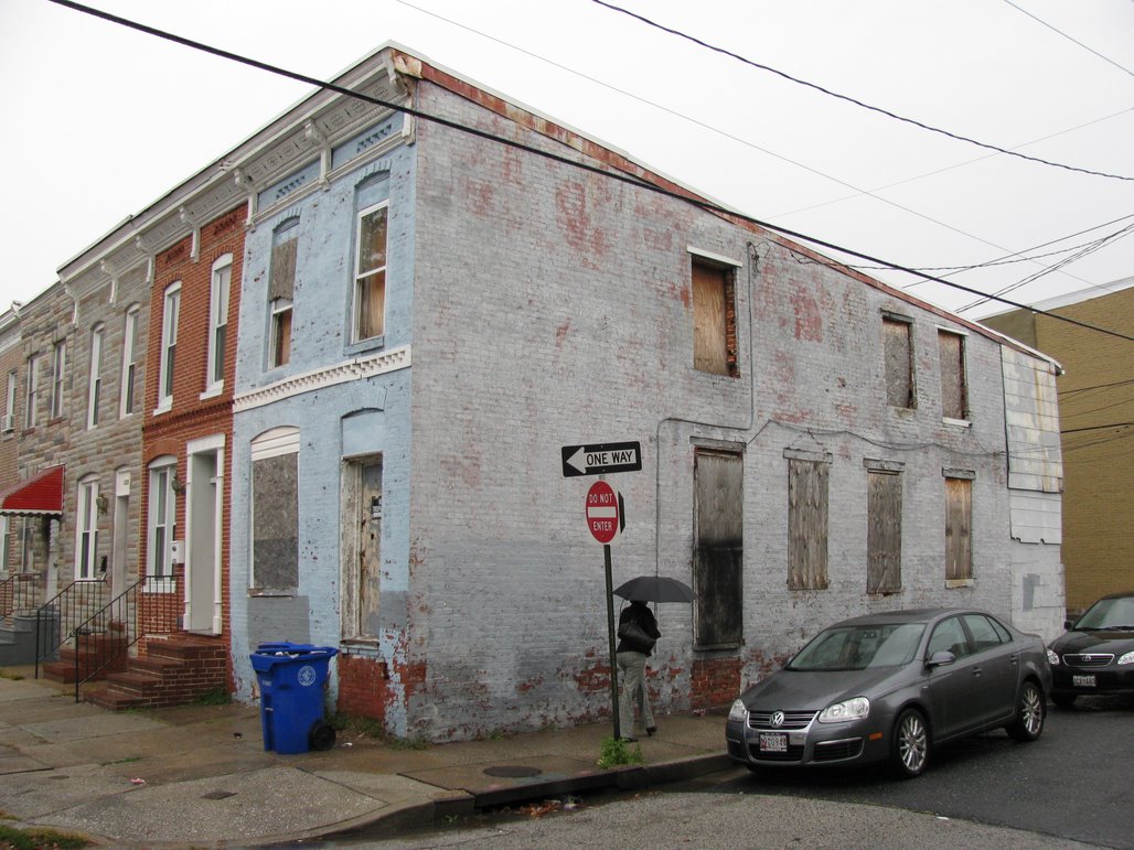 1224 W. Ostend Street before renovation. Baltimore City rowhome with boarded up windows and chipped paint.