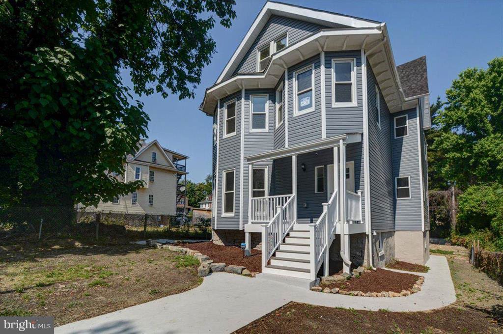 2125 Denison Street after renovation. Two-unit home with gray siding.