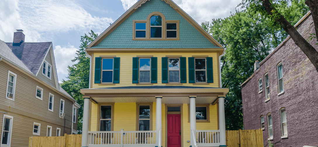 4107 Walrad Street. Yellow and green house with a red door.