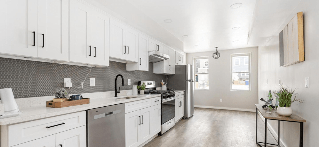 824 Edmondson Avenue interior after renovation. White kitchen, gray backsplash.